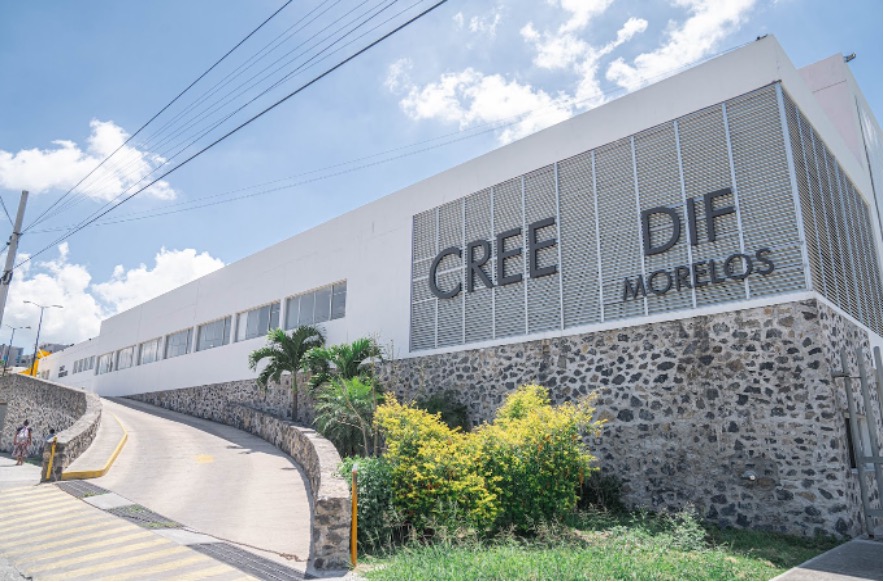 The image shows a long concrete slope with vegetation on its right side. This ramp serves as an entrance to a white building with a legend that says: CREE DIF MORELOS.